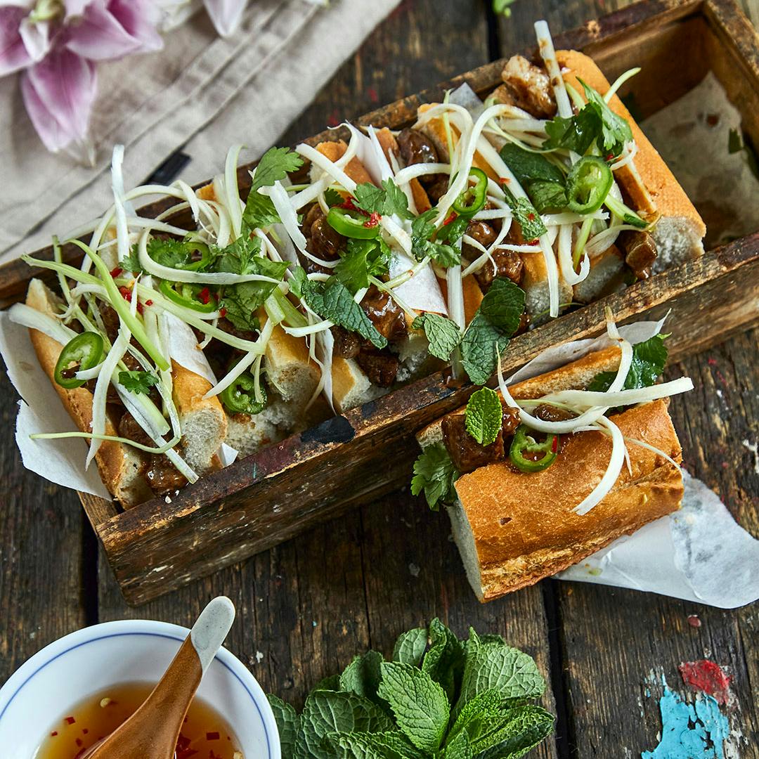Banh mi med grøntsager, krydderurter og krydret grisekød