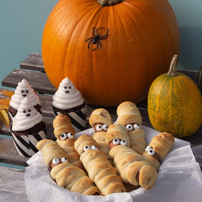 Halloween-festbord med spøgelseskager og mumie-pølsebrød.