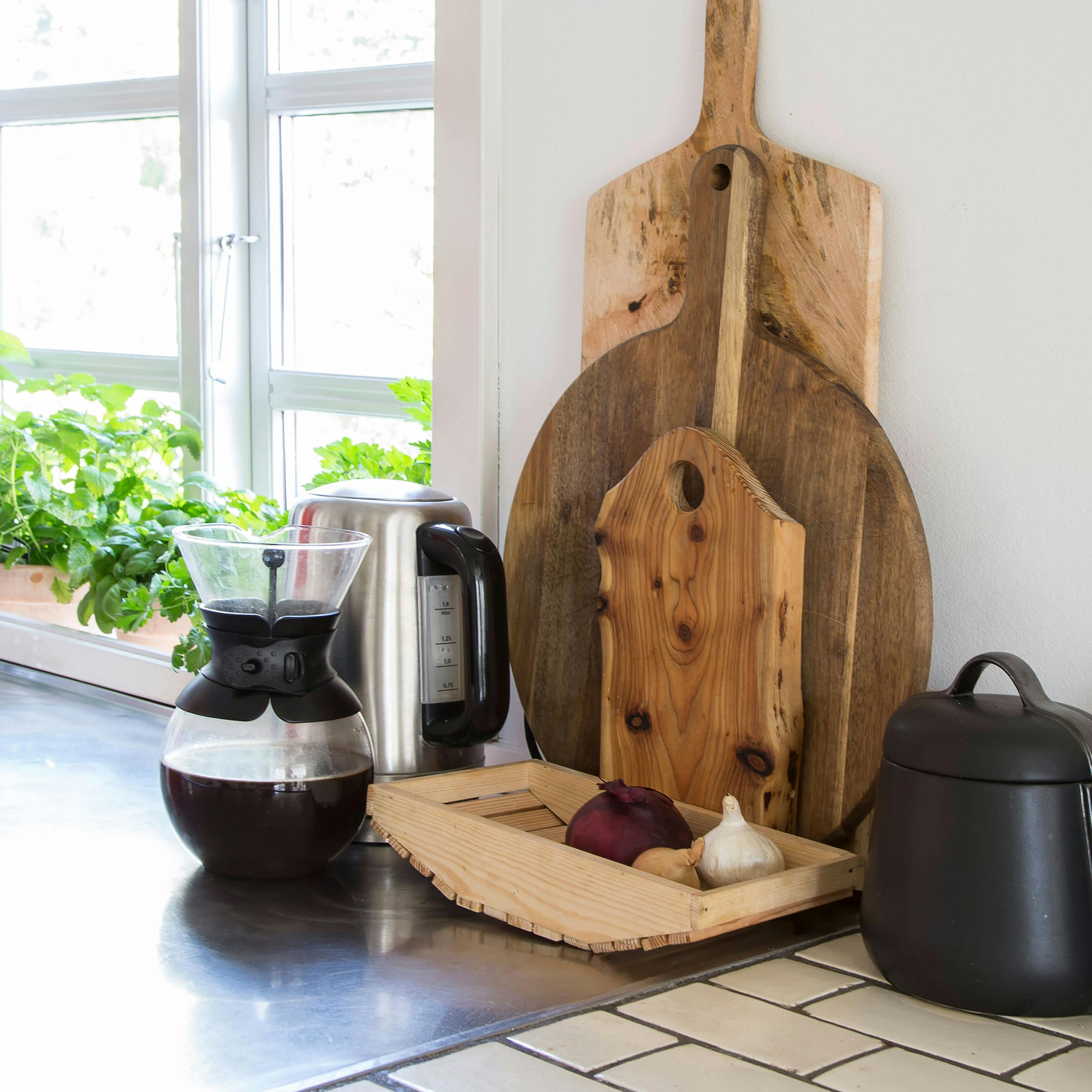 Et opryddet køkkenbord med kaffe og skærebræt.