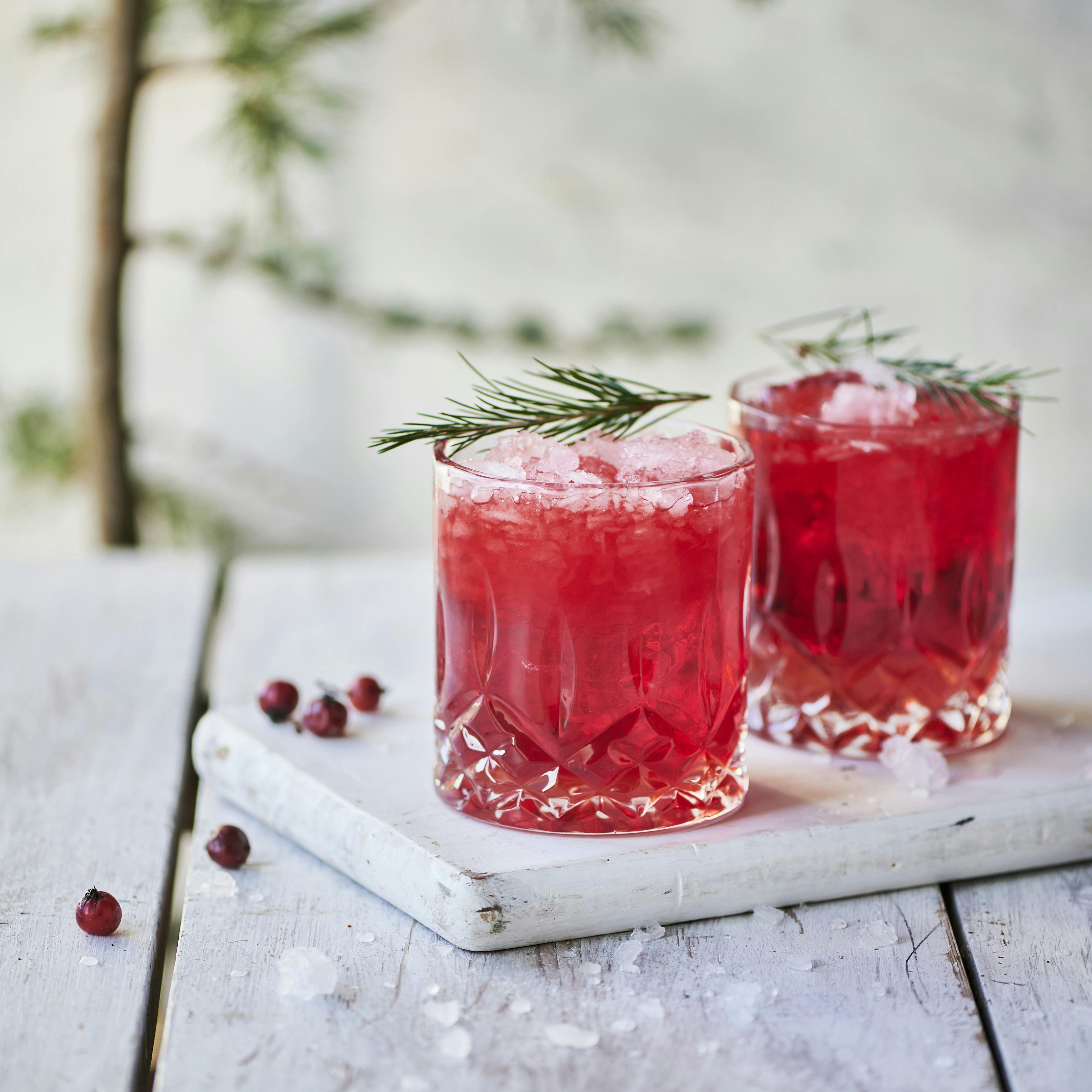 Rønnebær sour, en rød drink i krystalglas og gran som pynt