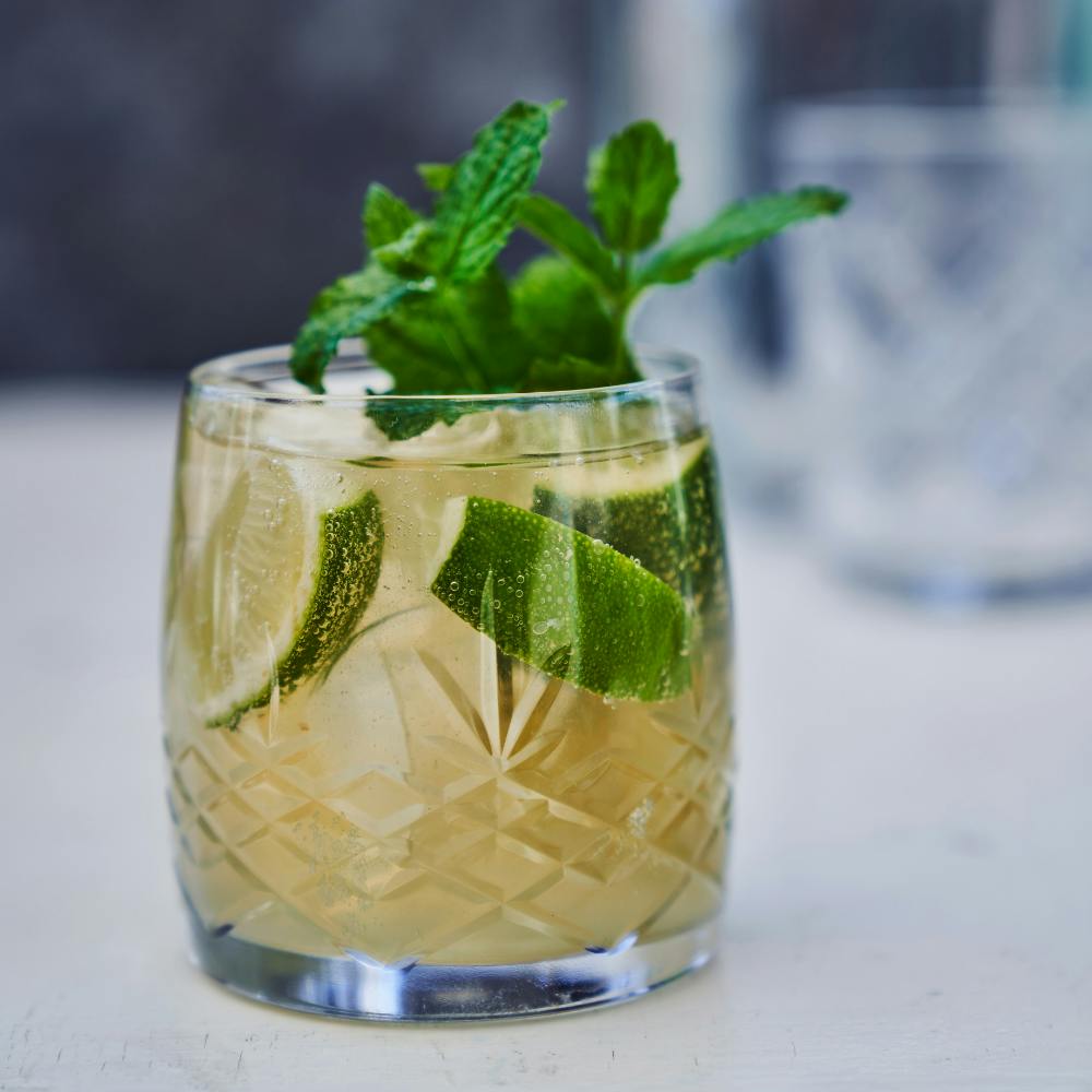 Drinken moscow mule med lime, mynte og isterner i krystalglas