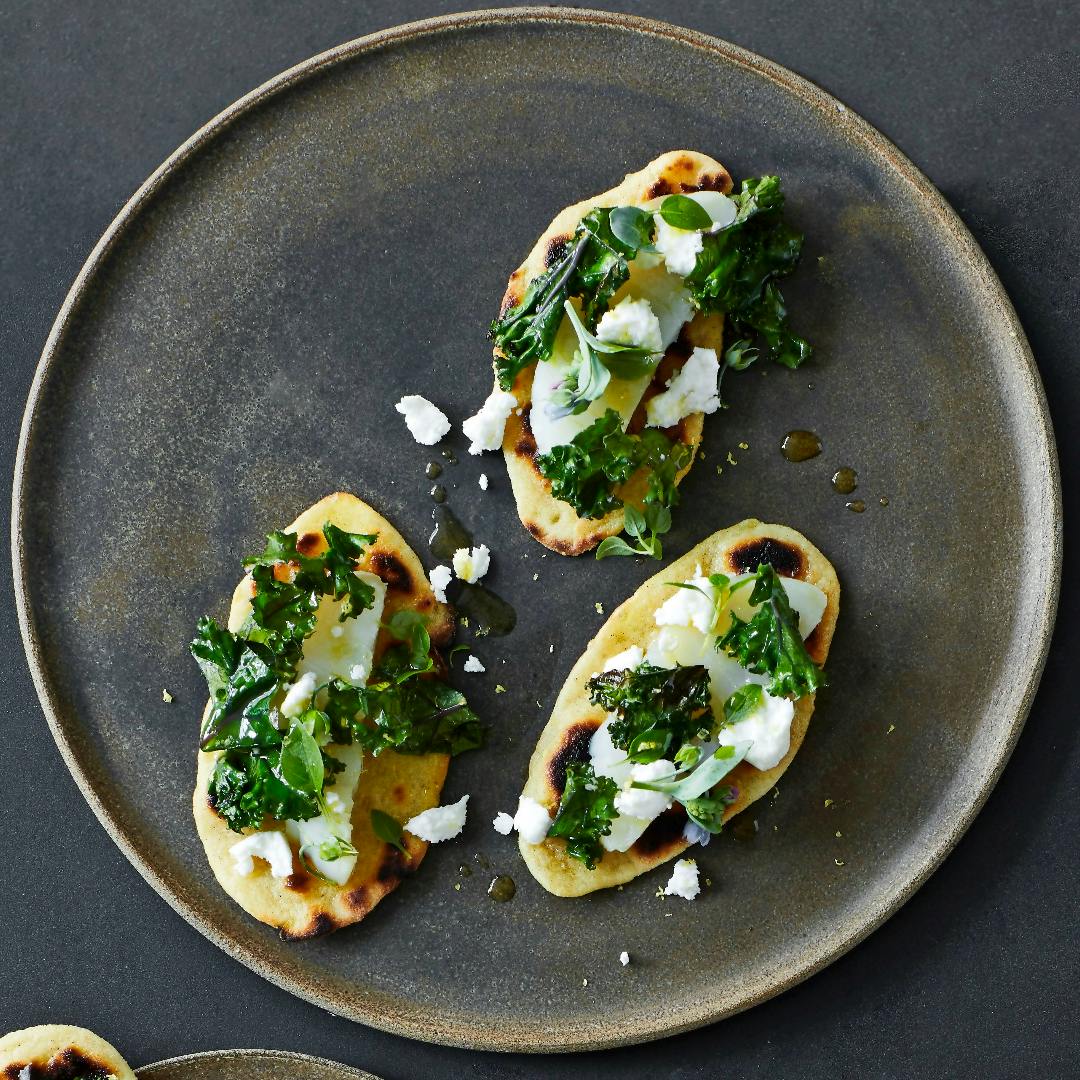 Kartoffelfladbrød med vinterkål, gedeost, saltet torsk og basilikum