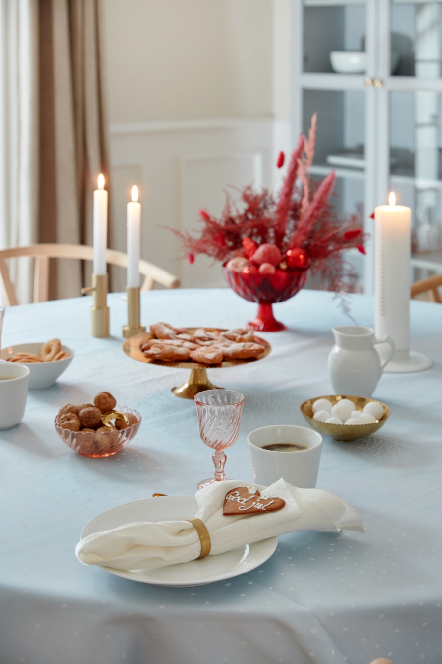 Tændte stearinys på dækket julebord med lyseblå dug