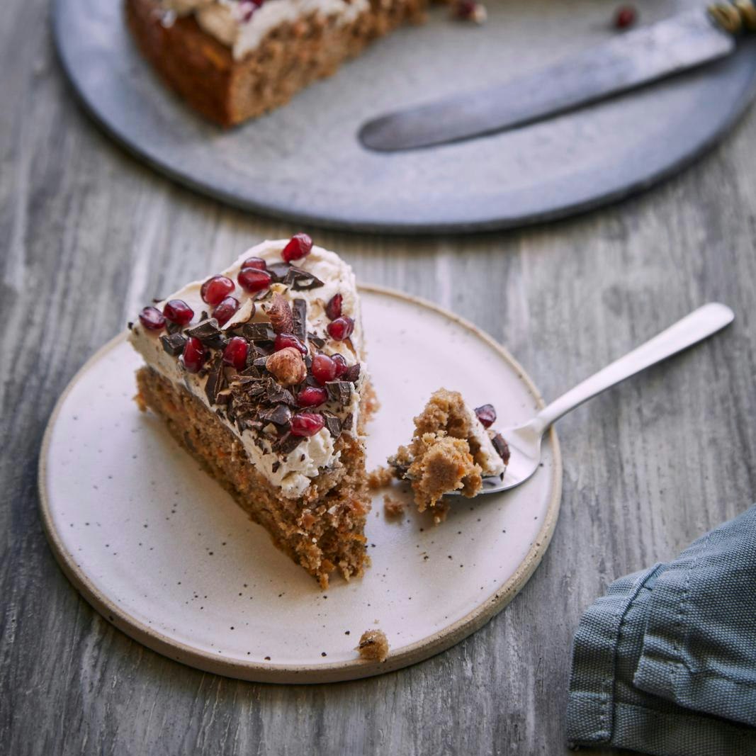 Gulerodskage med mascarponecreme og topping af granatæble, chokolade og hasselnød