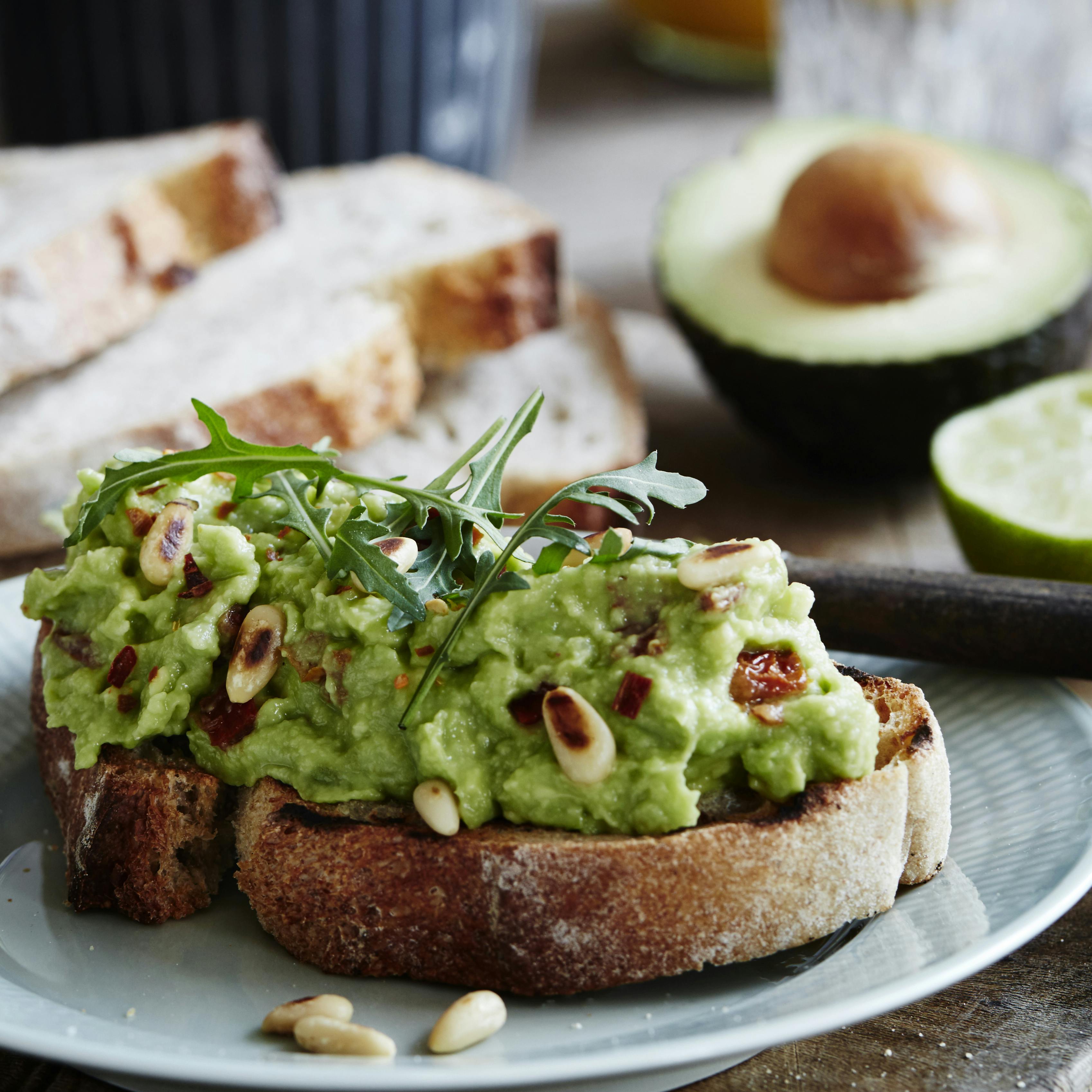 Toastet brød med avocadospread og pinjekerner.