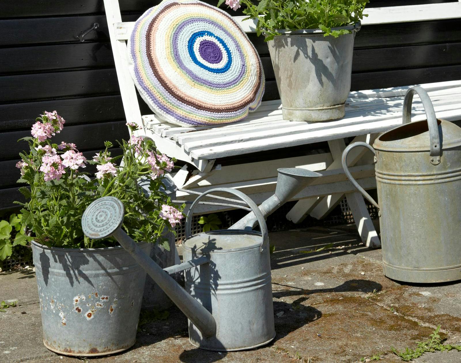 Vandkander i haven med blomster