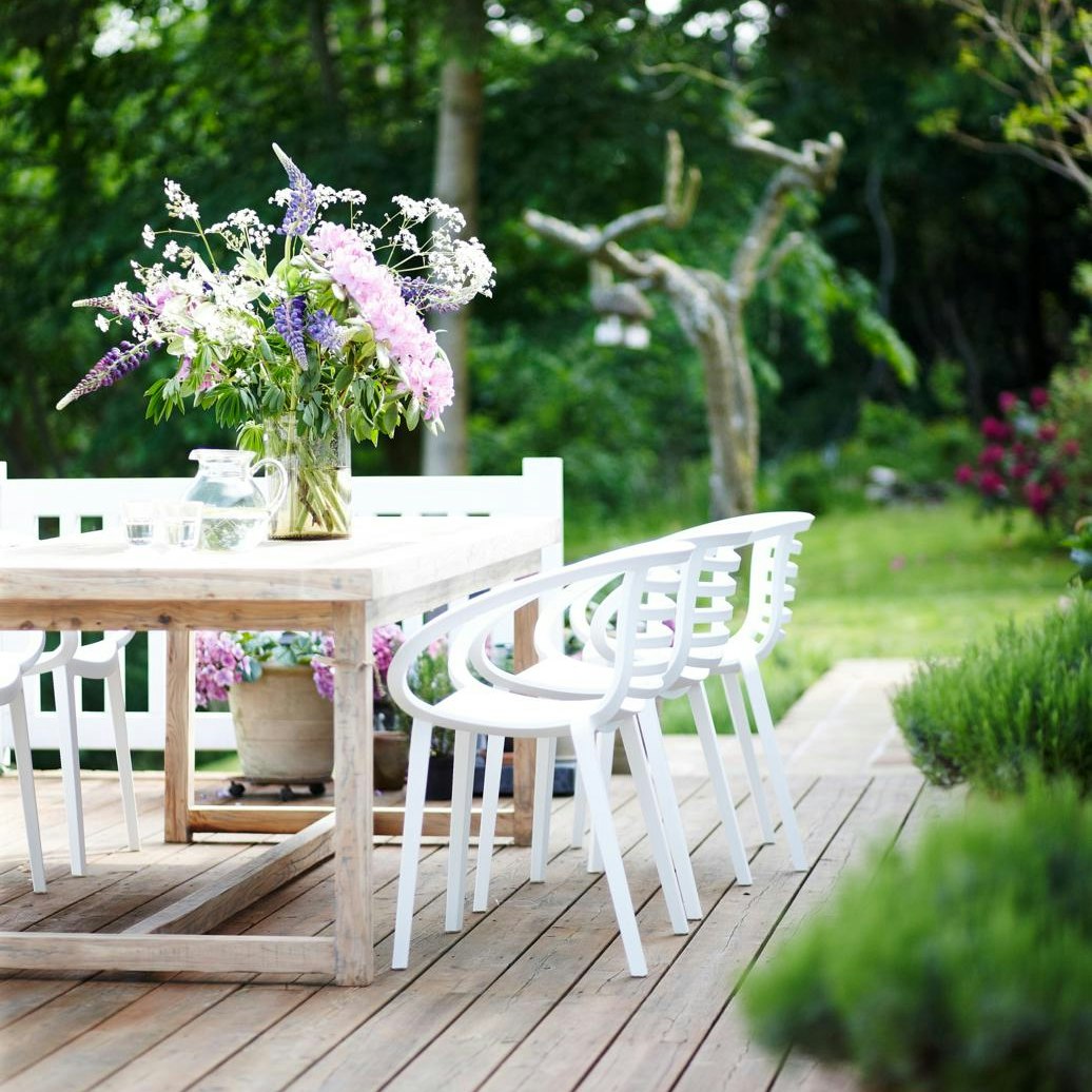 Hvide havemøbler med lyserød blomsterbuket på terrasse