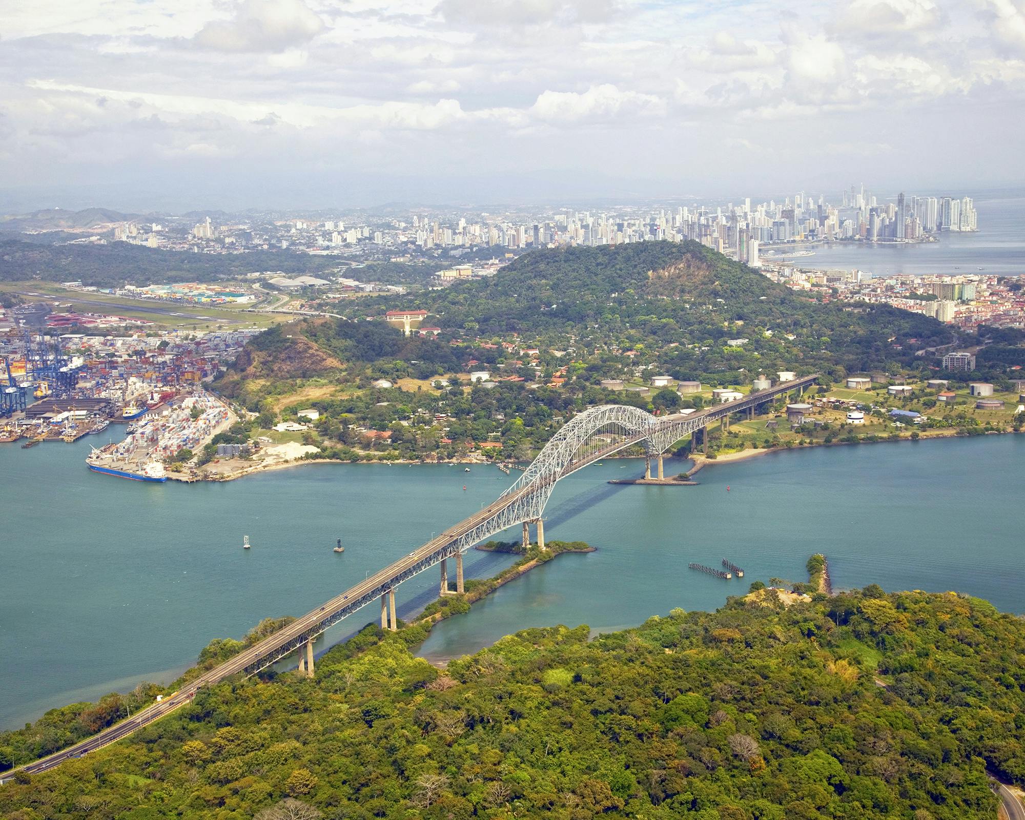 Aerial view of the Bridge of the Americas at the Pacific entrance to the Panama Canal with Panama City in the background.