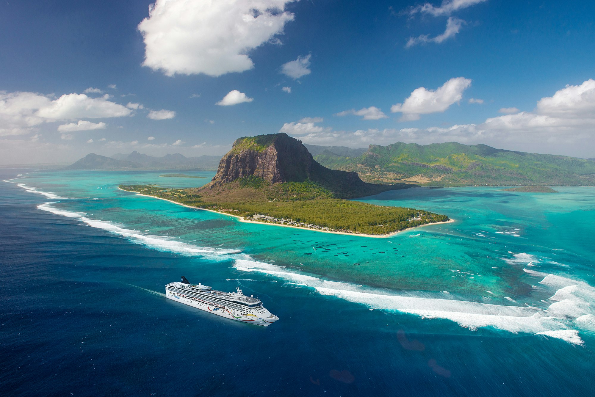 Aerial of Norwegian Dawn passing Le Morne mount, Port Louis, Mauritius island from helicopter.