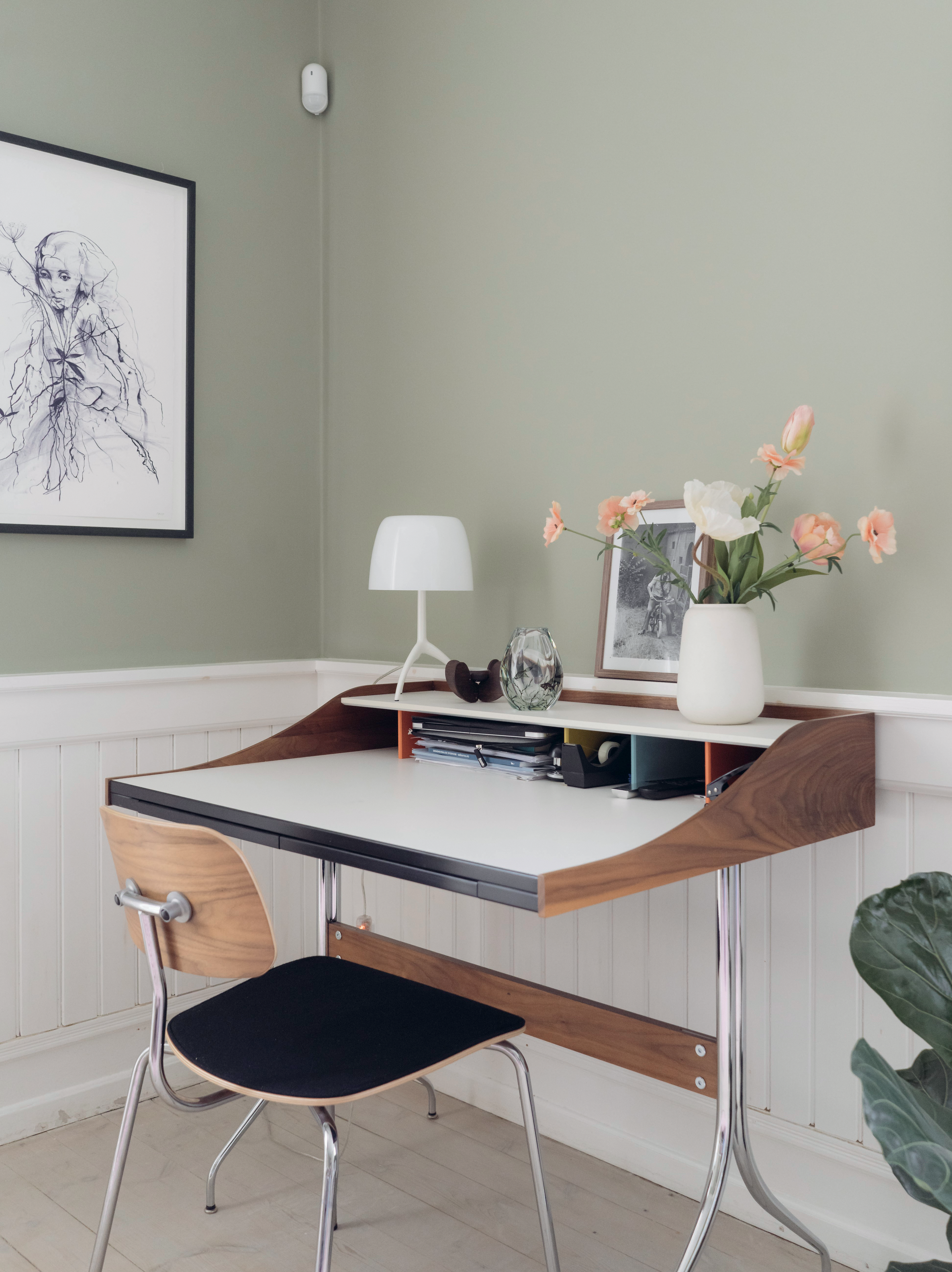 Roligt arbejdsrum med grøn vægfarve og skrivebord. 