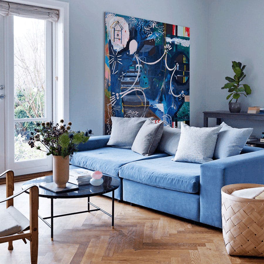 Blå sofa i stue med sildebensparket