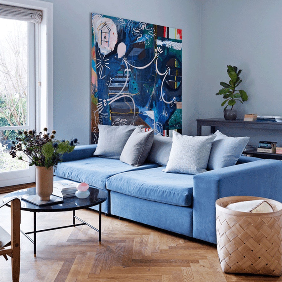 Blå sofa i stue med sildebensparket