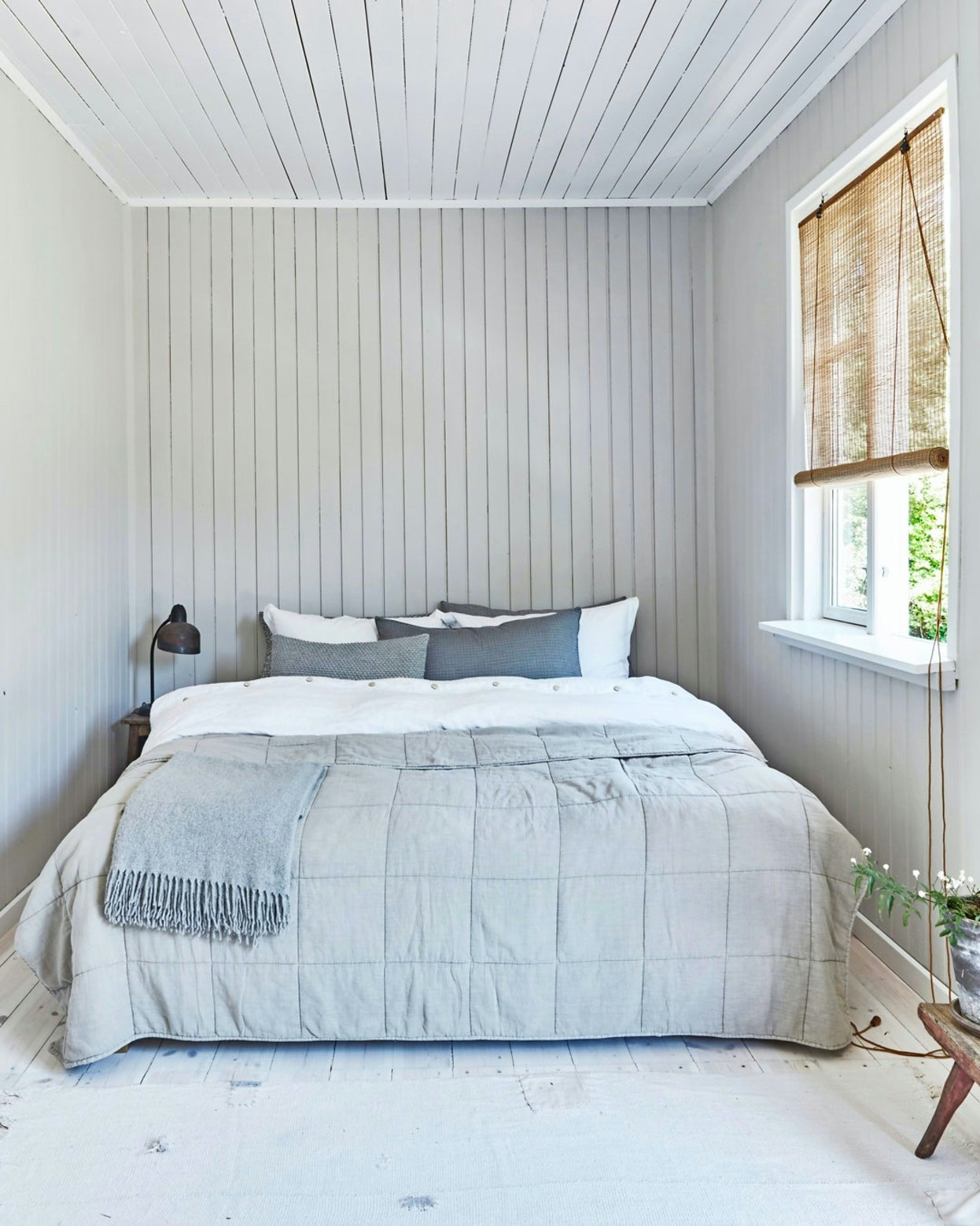 Lyst rum med quiltet sengetæppe