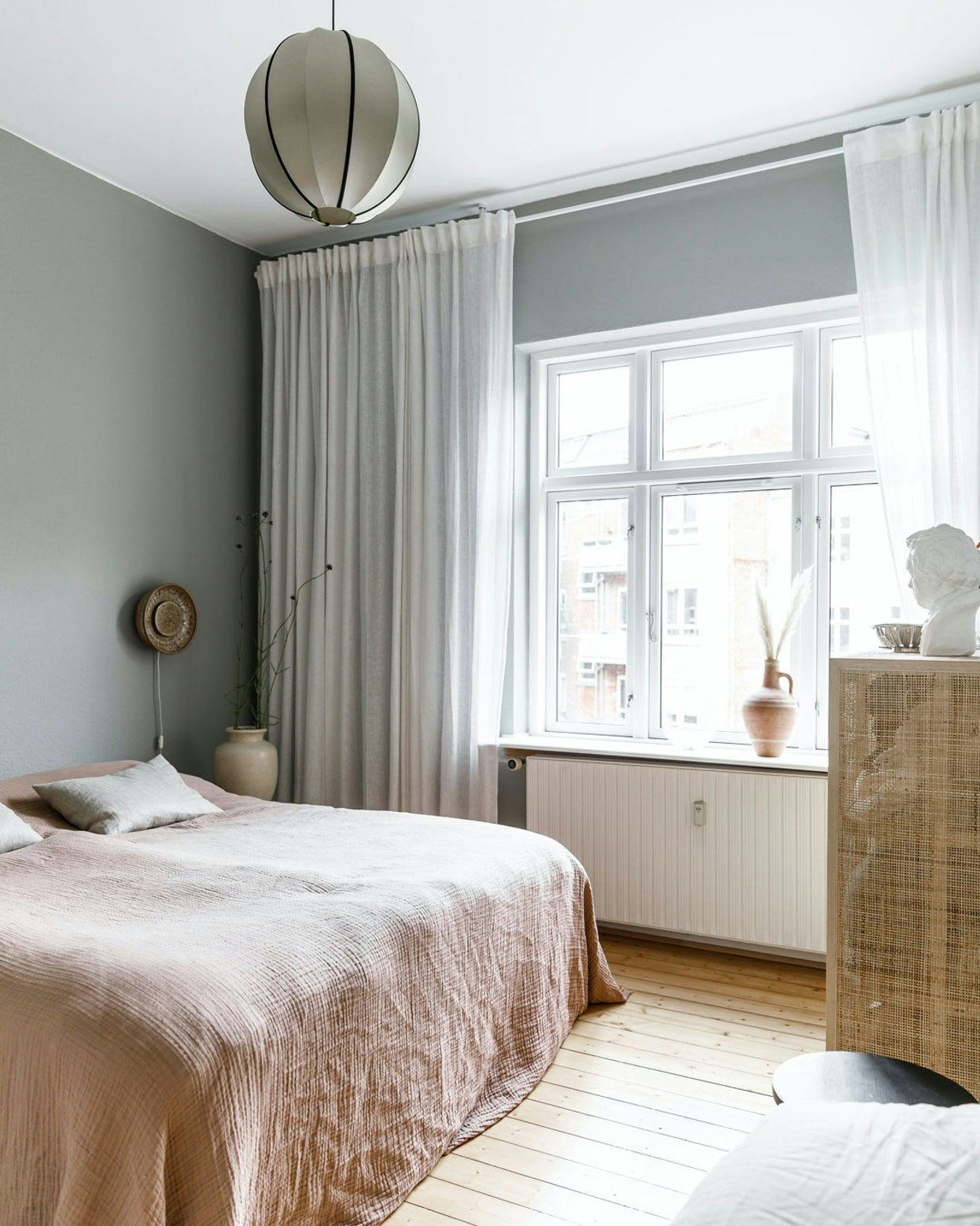 Lange gardiner og let sengetæppe skaber en luksuriøs følelse