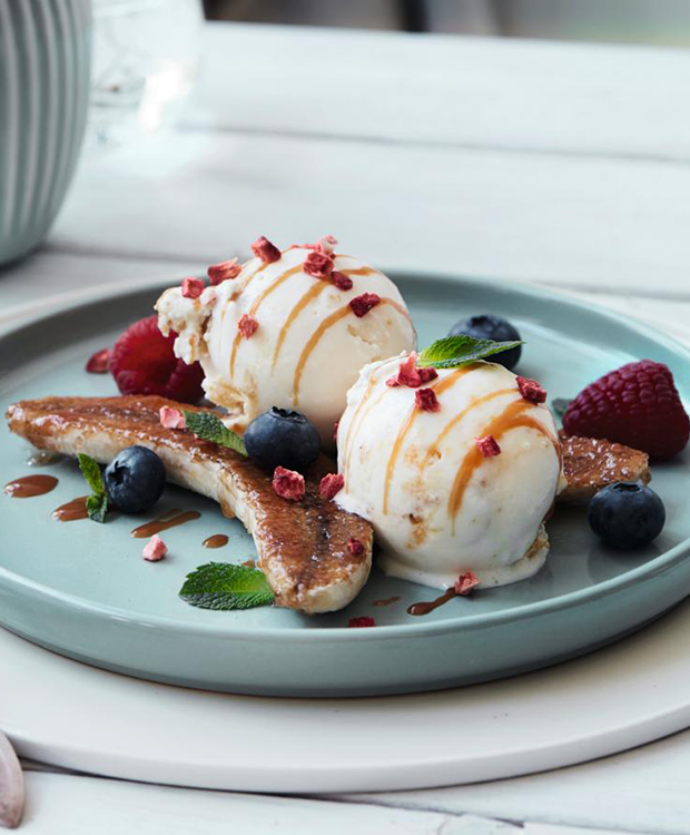 moderne bananasplit med karameliserede bananer og is med smag af cheesecake og passionsfrugt