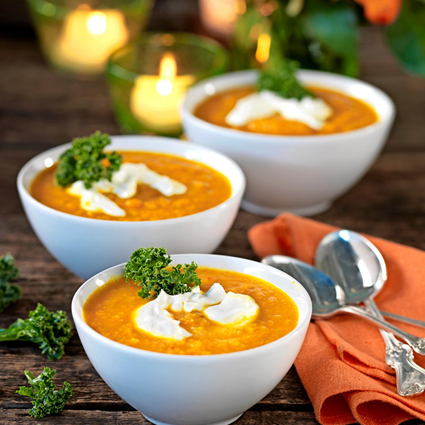Cremet gulerodssuppe serveret med græsk yoghurt og frisk persille