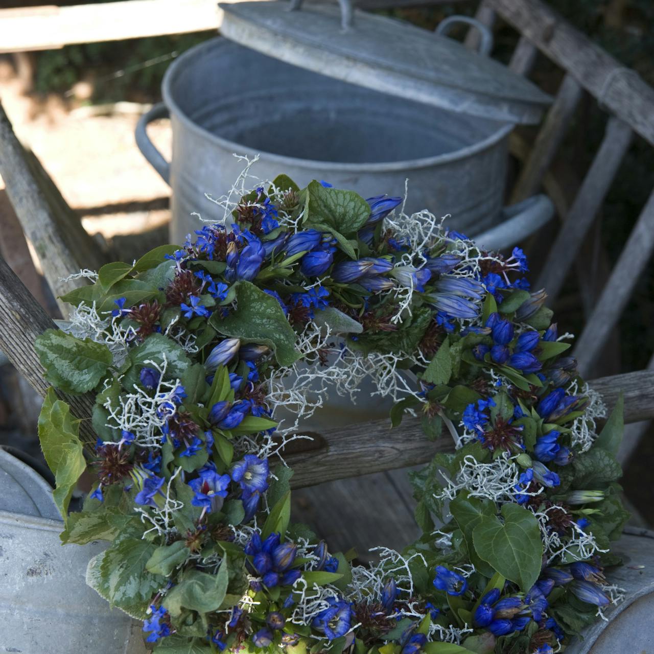 https://imgix.isabellas.dk/media/websites/isabellas-dot-dk/website/have/dekoration-og-buketter/tryl-med-blaa-blomster-p.jpg